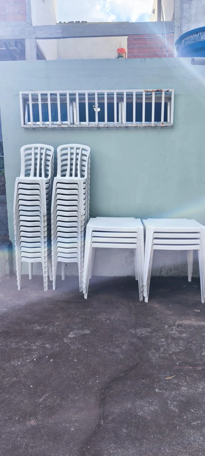 Cadeiras e mesas plásticas empilhadas para aluguel em Taquara