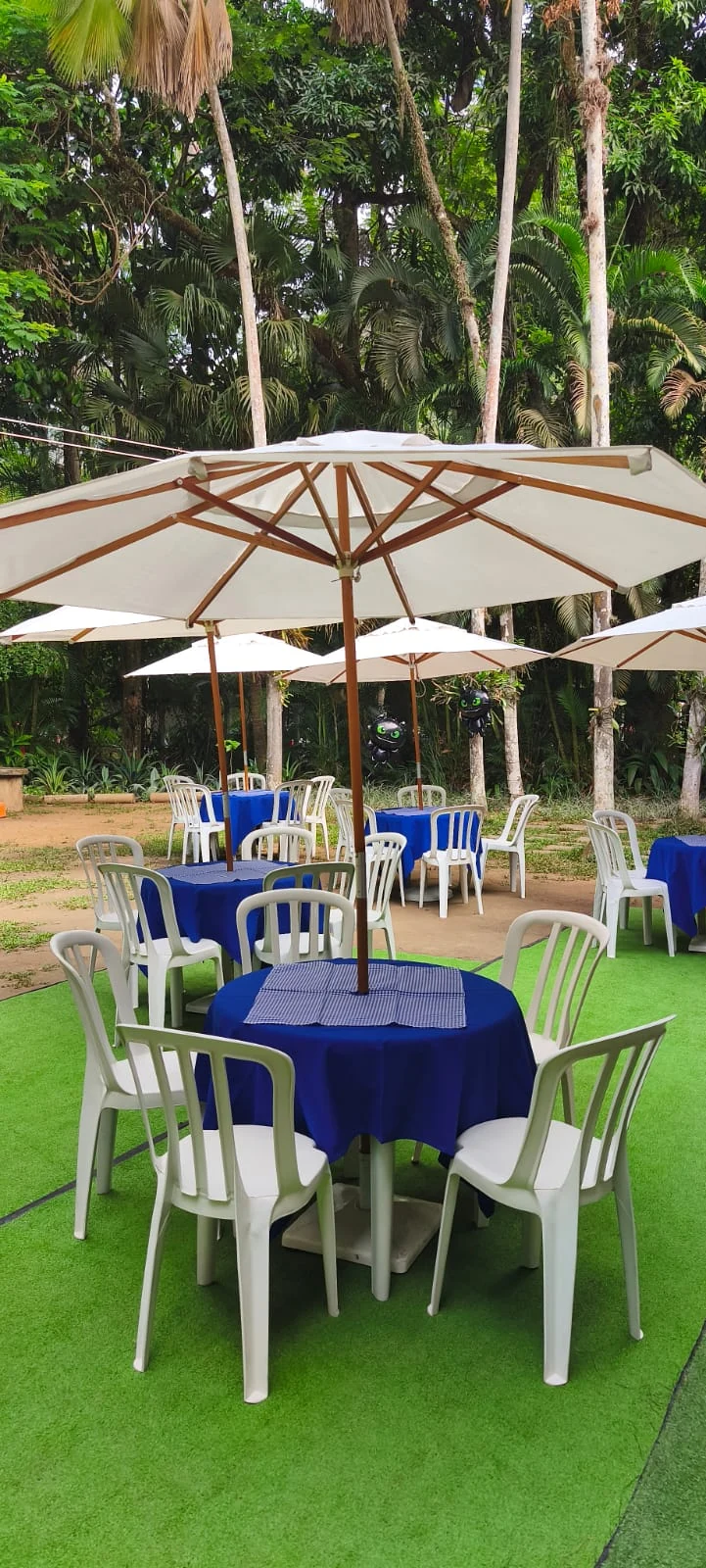 Ombrelone com mesa e cadeira montadas para festa em Taquara